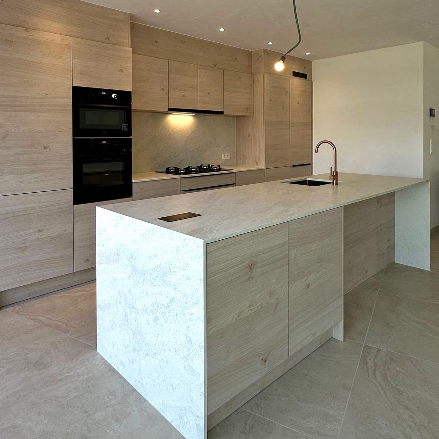 Moderne keuken met eiland in composiet en kasten in licht eiken